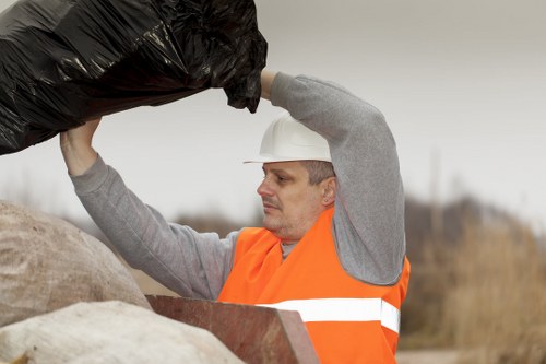 Workers loading mixed commercial waste into a van in a high-street location